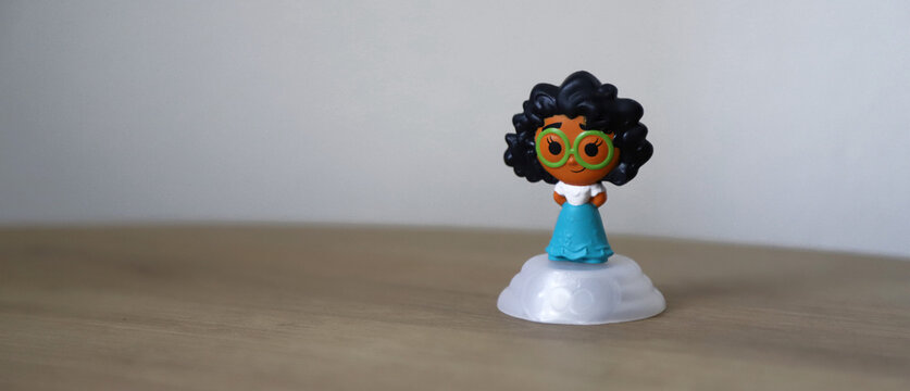 Mirabel Madrigal doll, protagonist of the Disney Pixar movie Encanto. Toy from the 100 years of Disney collection for the Macdonals Happy Meal. Isolated. Background with copy space.