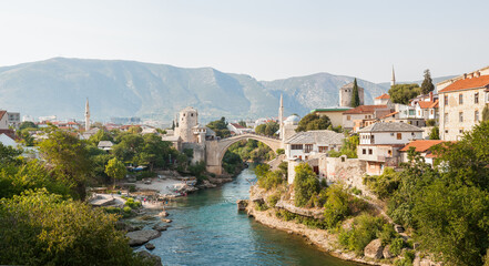 Old bridge in old town of Mostar at sunny day, Bosnia and Herzegovina. Tourist background for publication, design, poster, calendar, post, screensaver, wallpaper, cover, website. High quality photo