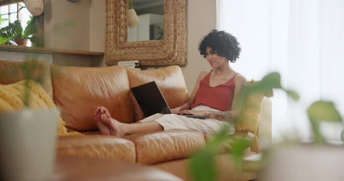 Laptop, search and happy woman on a sofa with social media, streaming or comic video at home. Pc, typing and female person relax in a living room for me time, movies or online comedy show in a house