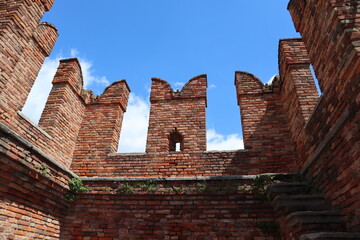 Red brick battlement against a bright blue sky, old town architecture, Scaliger Bridge, Verona, Italy, architectural element