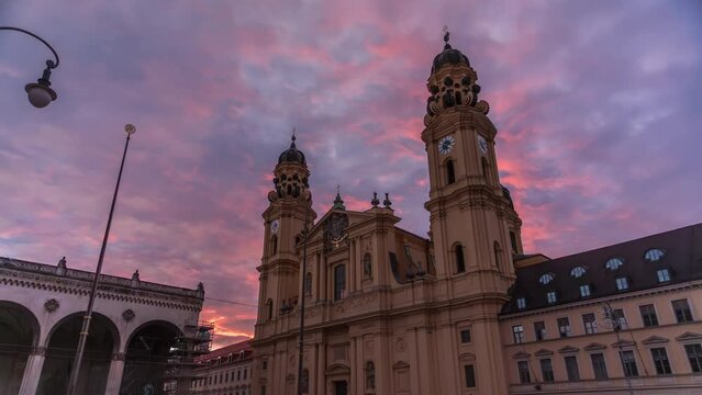 The Theatine Church of St. Cajetan (Theatinerkirche St. Kajetan) timelapse during sunset. A domed baroque Catholic church with striking yellow facade and ornate white stucco interior. Munich, Germany