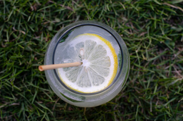 glass of lemonade with a sorbet and mint leaf on the grass