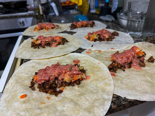 Culinary Craft in Progress: The Art of Assembling Authentic Homemade Tacos on a Bustling Kitchen Counter