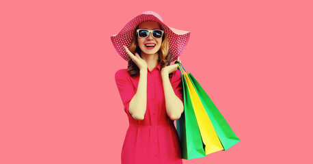 Beautiful happy smiling young woman model posing with shopping bags in summer hat