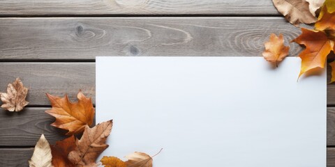 Blank paper on wooden table with winter background for December and dried fall leaves. - Powered by Adobe