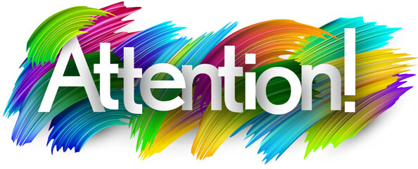 Attention paper word sign with colorful spectrum paint brush strokes over white.