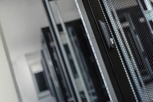 A close-up view of the door handle of an empty server rack.