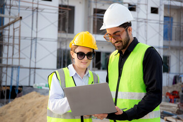 Team of architect or engineer looking laptop for inspection and planning construction at construction site, contractor or builder examining and checking project development house, industry concept.