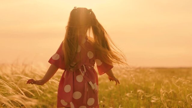Kid runs across meadow. Happy family concept, child dream. Little girl runs on grass, in sun, slow motion. Childhood dream concept. Happy little girl playing at sunset. Happy child in field at sunset.