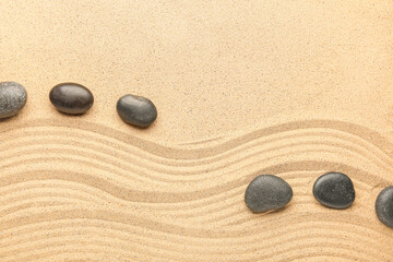 Fototapeta na wymiar Black spa stones on sand with lines, closeup. Zen concept