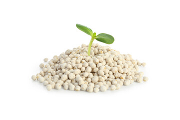 Green seedling growing from pile of granular fertilizer on white background