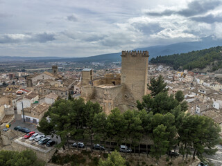 Obraz premium Aerial view of Moratalla castle in Murcia province Spain dominating the village with square great tower, nicely restored monument from medieval times