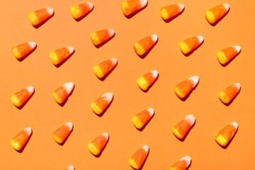 Many candy corns on orange background