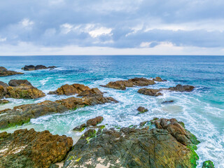 Rain clouds, rocks and sunrise at the seaside