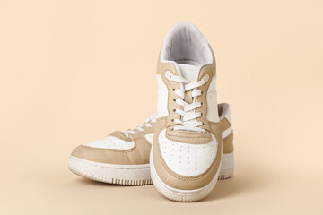 Stylish sneakers on beige background