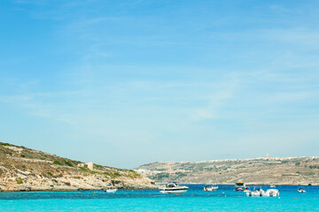 Naklejka premium Turquoise blue lagoon with boats and rocky coastline, mediterranean sea vacation destination, summer travel and leisure