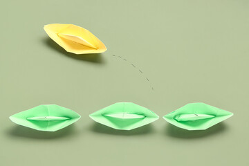 Paper origami boats on green background. Business idea concept
