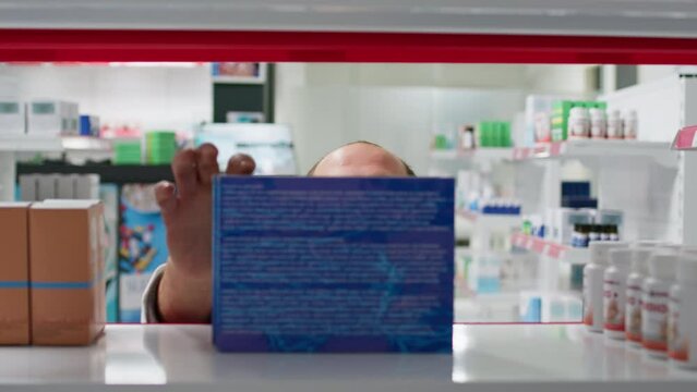 POV of employee putting supplements boxes on display, organizing types of medicaments in drugstore. Medical clerk placing vitamins or prescribed treatments, healthcare industry. Tripod shot.