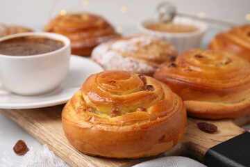 Delicious rolls with raisins on table, closeup. Sweet buns