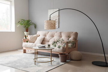 Interior of modern living room with cozy white sofa, coffee table and standard lamp