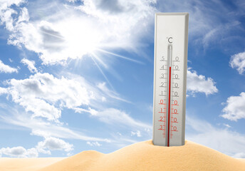 Thermometer in sand showing high temperature during hot summer day