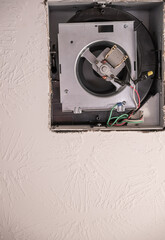 Open cover of a ceiling fan in a bathroom in order to replace a broken unit