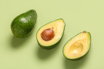 Fresh ripe avocados on green background