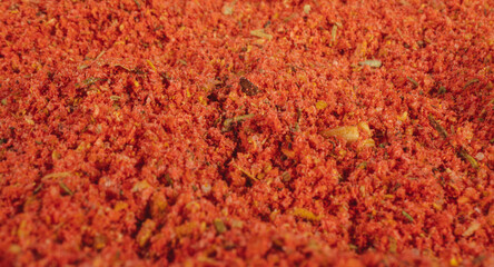 Assorted seasonings in a pile. Background of red paprika powder. Close up of red paprika in a spice shop, texture.