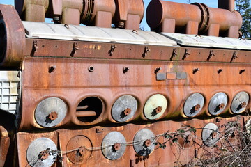 Diesel train engine rusting in field.