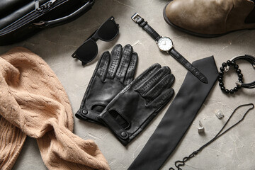 Composition with leather male gloves and stylish accessories on grunge background