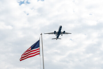 Airplane flying in the sky against the background of the american flag