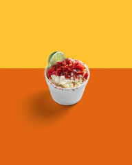 Corn Preparation in a Cup, Esquite, Mexican Snack, Street Food, Spicy, Chamoy, Chili Powder, Minimalist orange Background
