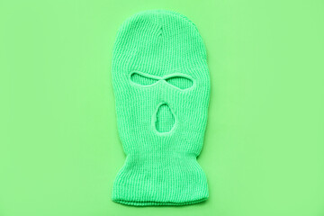 Stylish balaclava on green background