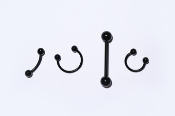Set of black jewelry for piercing on light background