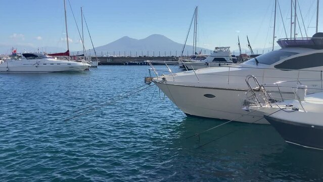Yachts in the marina of Naples port with Mount Vesuvius behind. Static view