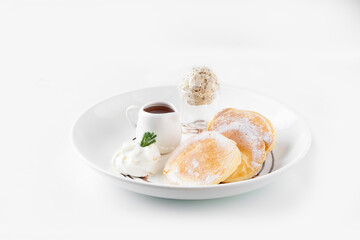 Fluffy and soft pancakes with honey and vanilla ice cream, on white plate, top view 