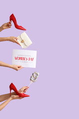 Female hands with festive postcard, handbag and high heel shoes on lilac background. International Women's Day celebration