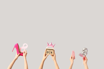 Female hands with balloon in shape of figure 8, calendar and high heel shoe on white background. International Women's Day celebration