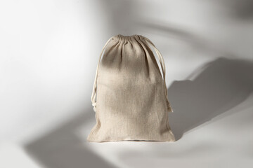 Tied small bag made of natural fabric on a white background. Cotton bag with drawstrings.
