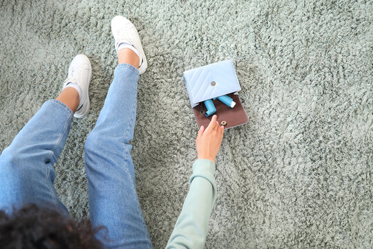 Young woman taking asthma inhaler out of bag in bedroom, top view
