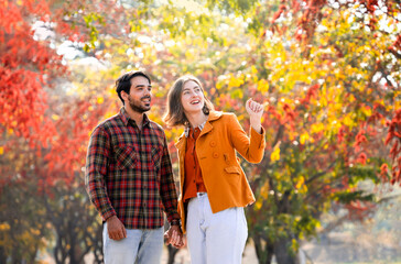 Fototapeta premium people lifestyle,love,relationship and family concept,happy young caucasian couple hands holding each other walking in autumn park