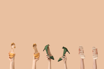 Women with stylish high-heeled shoes on beige background