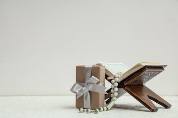 Gift box with Koran and prayer beads for Ramadan on white table