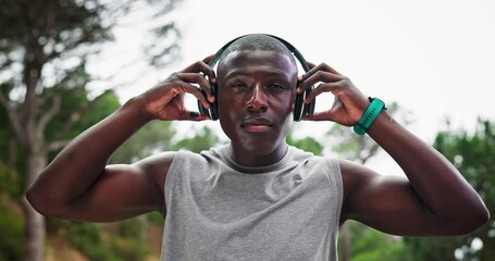 Road, fitness and black man with headphones, streaming music and runner listening to a motivational podcast. African person, athlete and guy with headset, sweating or cardio in a park, radio or audio