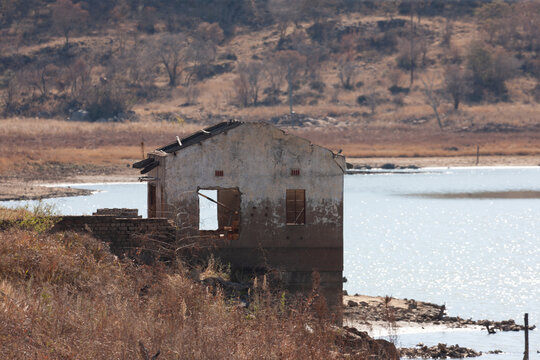 ruined house at the shore of the lake in the dush in a late afternoon