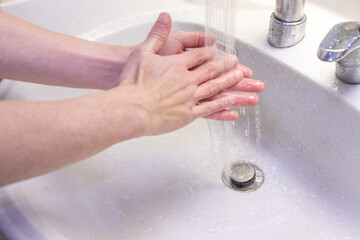 洗面台のシンクで手を洗う