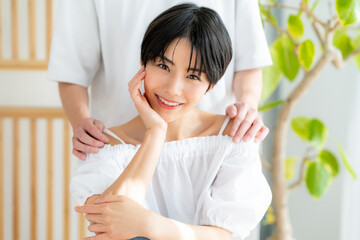 肩に男性の手を置かれる若い女性の美容イメージ