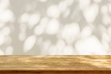 Empty wood table top on beige wall texture with tree leaves shadow background - obrazy, fototapety, plakaty