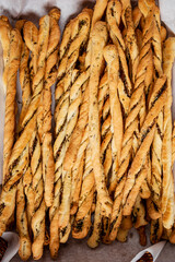 Breadsticks in a basket on a wooden background.