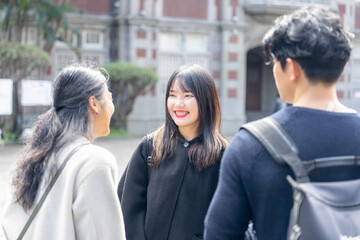 台湾台北市大安区の大学で３人の大学生男女が話している様子 Three college students talking at a university in Da'an District, Taipei City, Taiwan